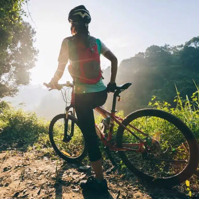 A woman riding her bike on a scenic trail, Sri Lanka