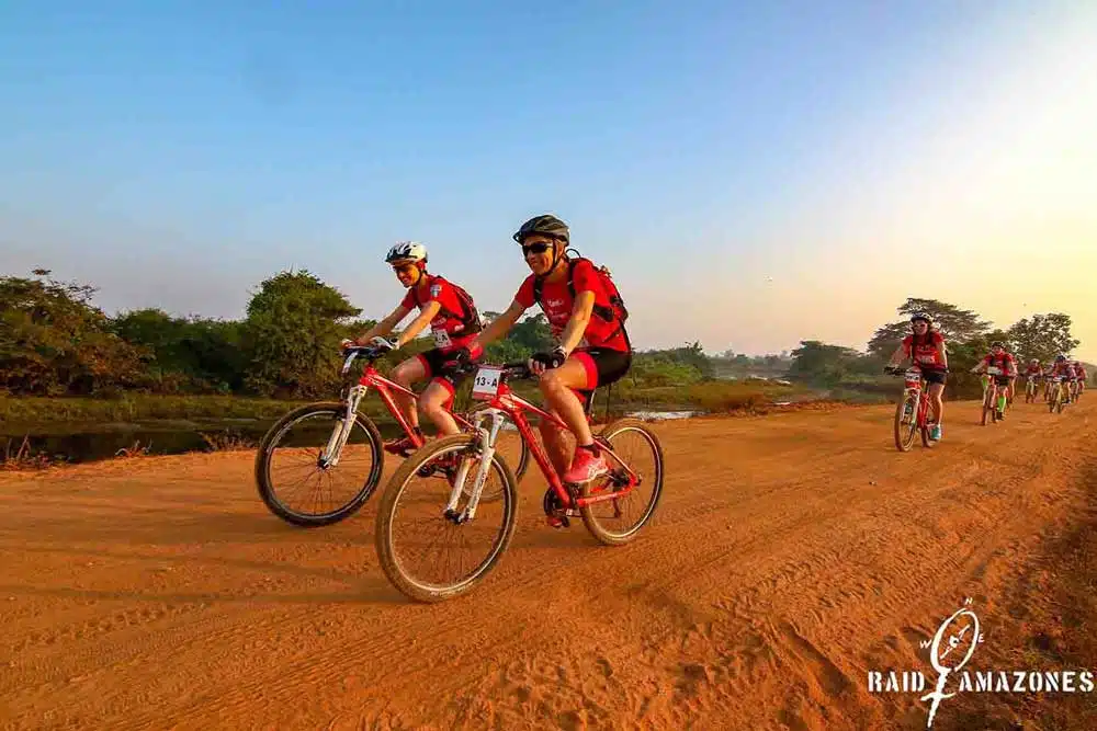 A group of cyclists riding through the scenic countryside of Sri Lanka on a bike tour Raid Amazones.